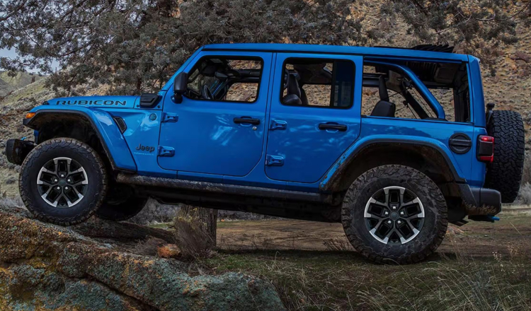 Blue jeep wrangler driving up rocky terrain